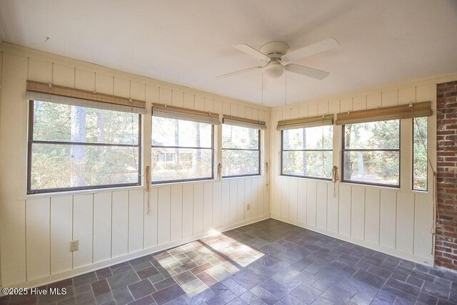 unfurnished sunroom with ceiling fan and a wealth of natural light