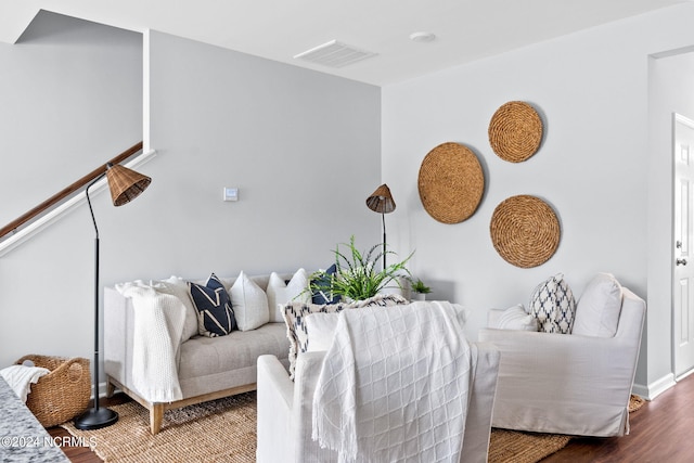 living area with visible vents, baseboards, and wood finished floors