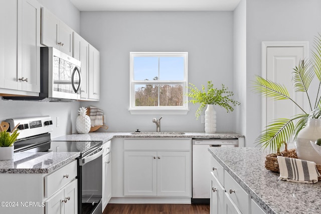 kitchen with white cabinetry, dark wood finished floors, appliances with stainless steel finishes, and a sink