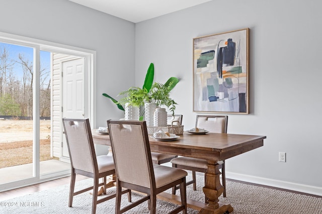 dining room featuring baseboards and light wood finished floors