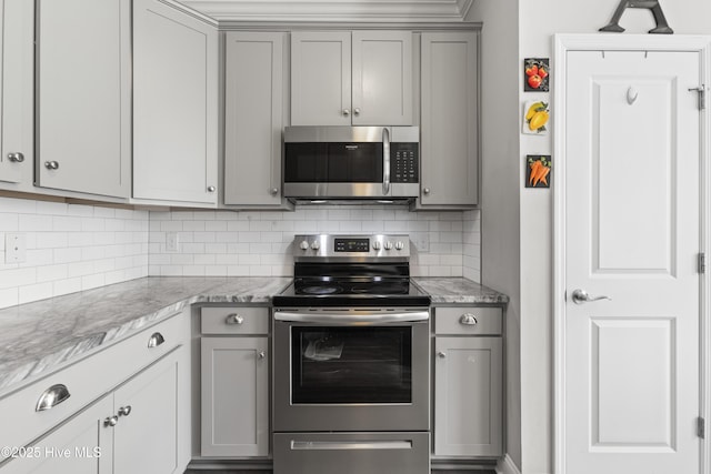 kitchen with gray cabinetry, backsplash, and appliances with stainless steel finishes