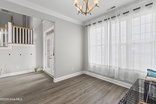 empty room with crown molding, a notable chandelier, and dark hardwood / wood-style flooring