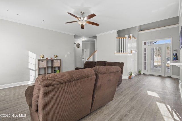 living room with wood-type flooring, ornamental molding, and ceiling fan