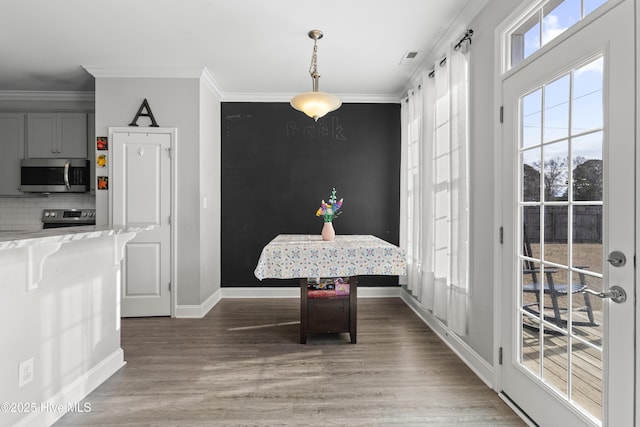 dining room with crown molding, plenty of natural light, and breakfast area