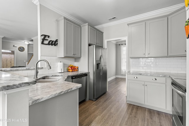 kitchen featuring sink, crown molding, dark wood-type flooring, gray cabinets, and appliances with stainless steel finishes