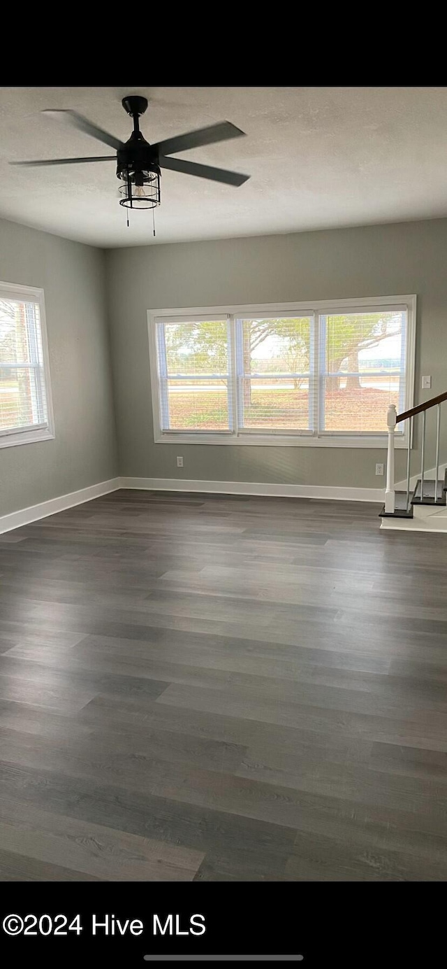 unfurnished room featuring dark hardwood / wood-style flooring, plenty of natural light, and ceiling fan