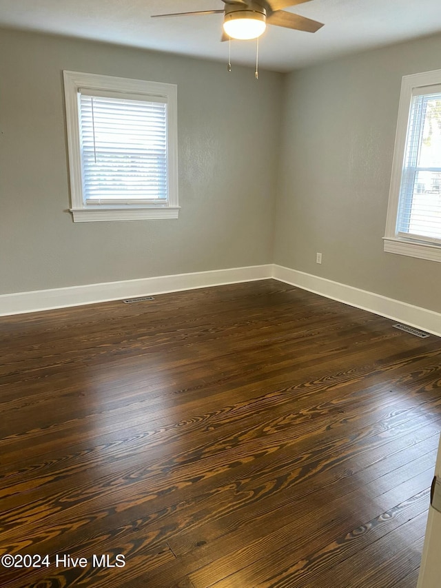 unfurnished room featuring ceiling fan and dark wood-type flooring