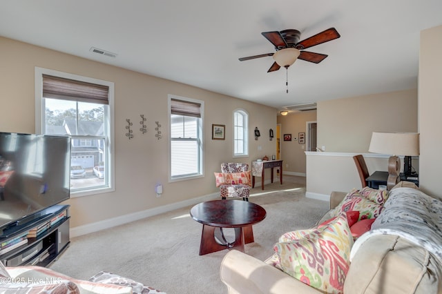 carpeted living room with ceiling fan and plenty of natural light