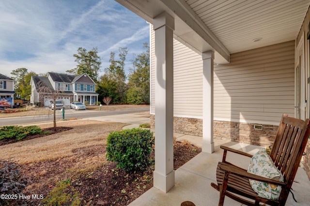 view of patio / terrace with a porch and a garage