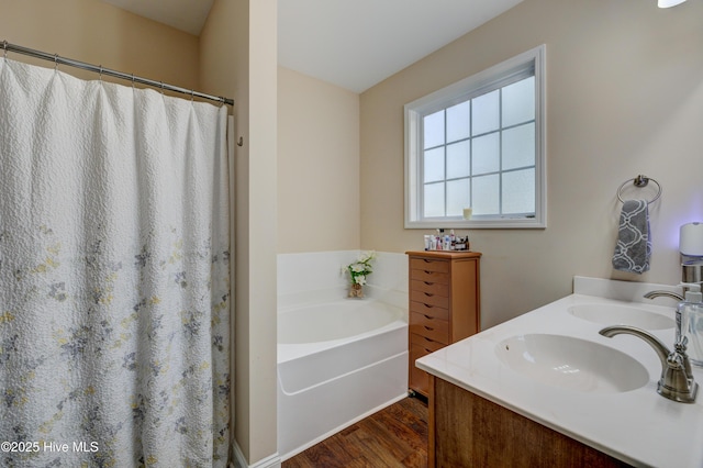 bathroom with hardwood / wood-style floors, vanity, and a bathtub