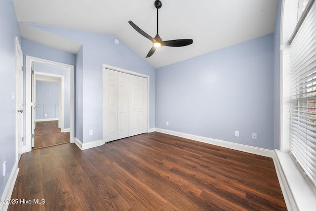 unfurnished bedroom with ceiling fan, a closet, dark hardwood / wood-style floors, and vaulted ceiling