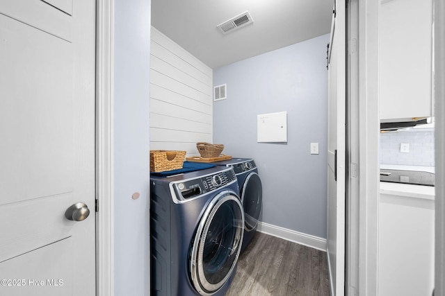 laundry area featuring washer and dryer and dark hardwood / wood-style flooring