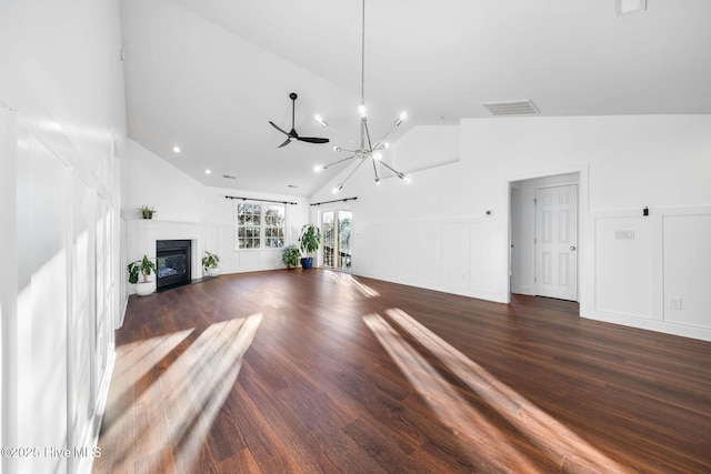 unfurnished living room featuring ceiling fan with notable chandelier, dark hardwood / wood-style floors, and vaulted ceiling