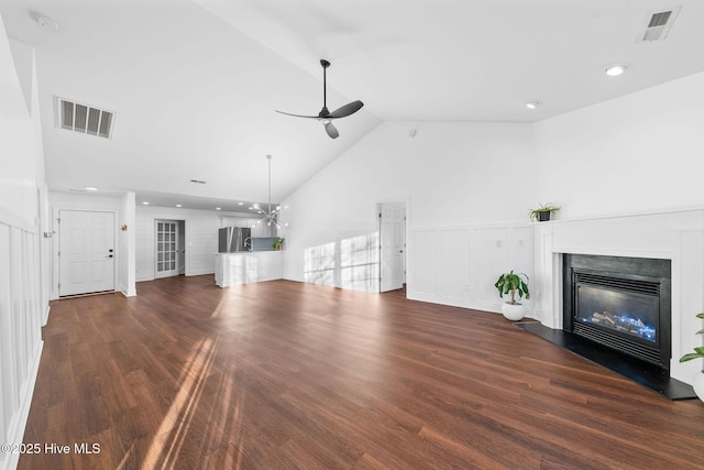 unfurnished living room featuring dark hardwood / wood-style flooring, high vaulted ceiling, and ceiling fan