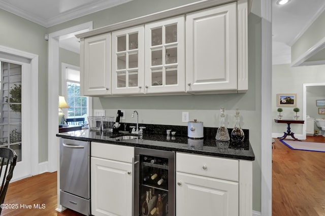 kitchen with white cabinetry, beverage cooler, and light wood-type flooring