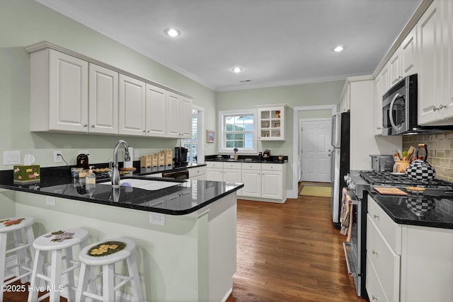 kitchen with stainless steel appliances, white cabinets, and kitchen peninsula