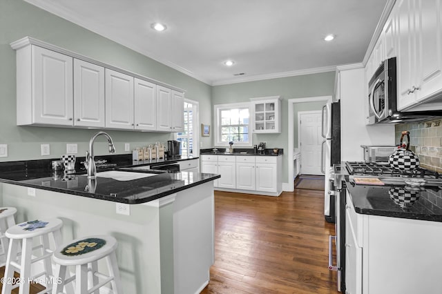 kitchen with white cabinetry, stainless steel appliances, and kitchen peninsula