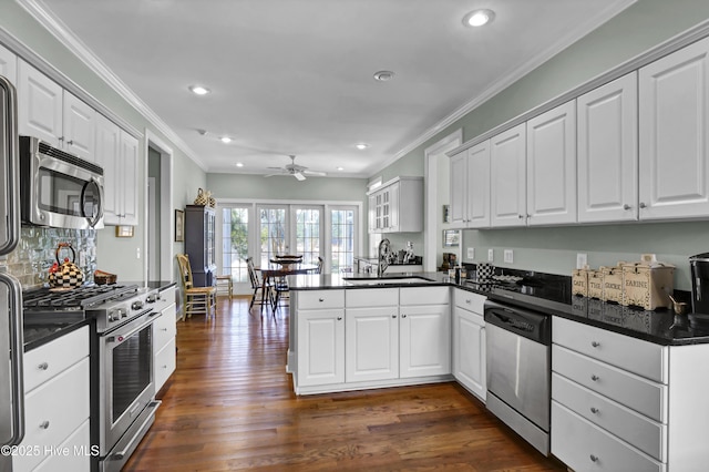 kitchen featuring appliances with stainless steel finishes, kitchen peninsula, sink, and white cabinets