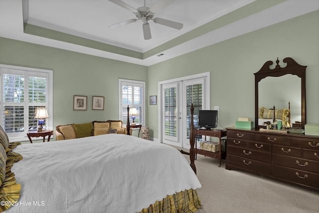 bedroom featuring crown molding, a tray ceiling, light carpet, and access to outside