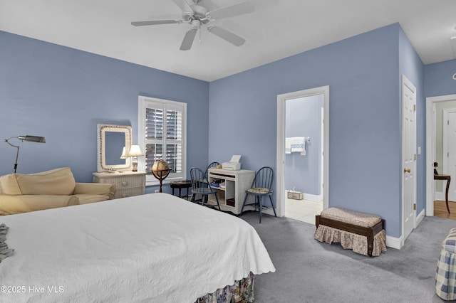 carpeted bedroom with ensuite bathroom and ceiling fan