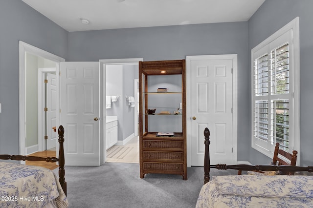 bedroom featuring connected bathroom and carpet flooring