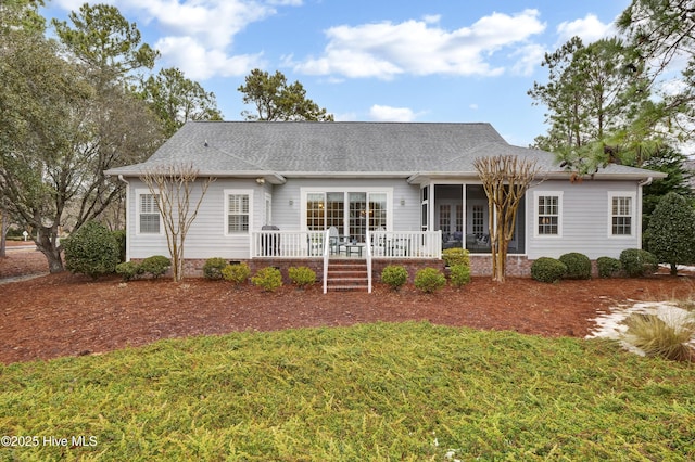 back of house featuring a sunroom and a lawn