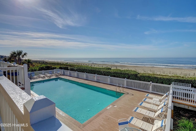 view of pool featuring a view of the beach and a deck with water view