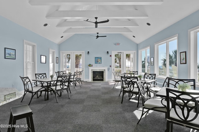 dining room with beam ceiling, carpet flooring, ceiling fan, and a premium fireplace