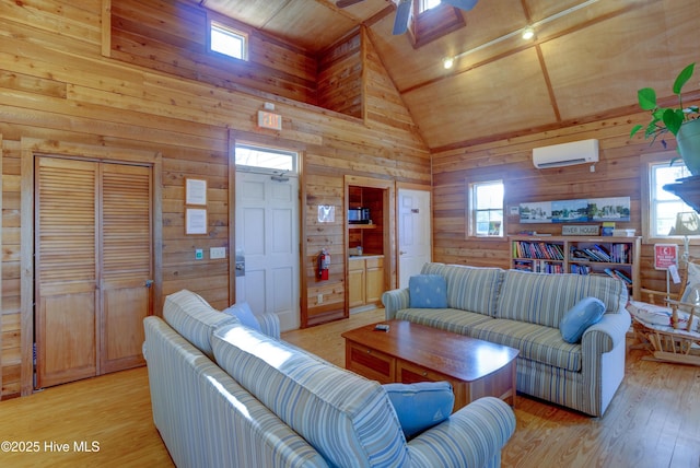 living room featuring light hardwood / wood-style flooring, a wall unit AC, and wood walls