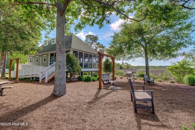 view of playground featuring stairs and a sunroom