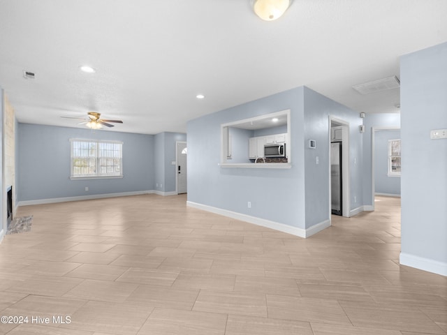 unfurnished living room with ceiling fan