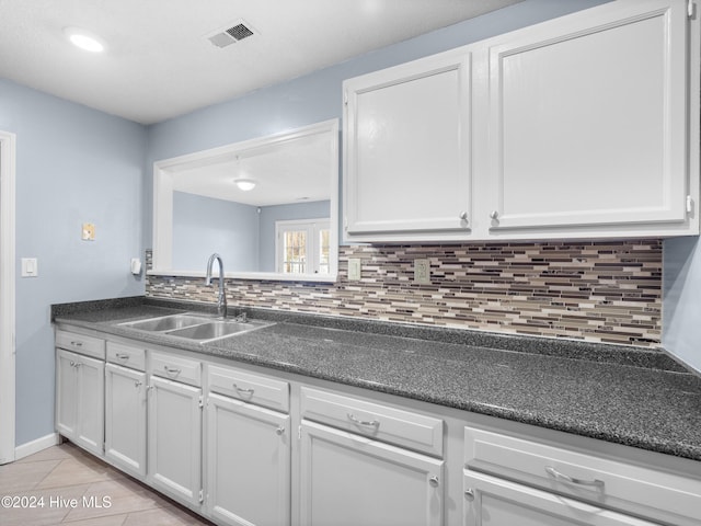 kitchen with white cabinets, tasteful backsplash, and sink