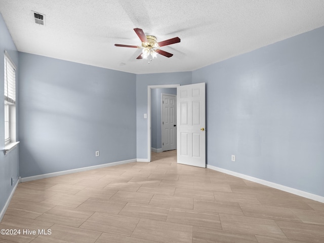 empty room featuring a textured ceiling and ceiling fan