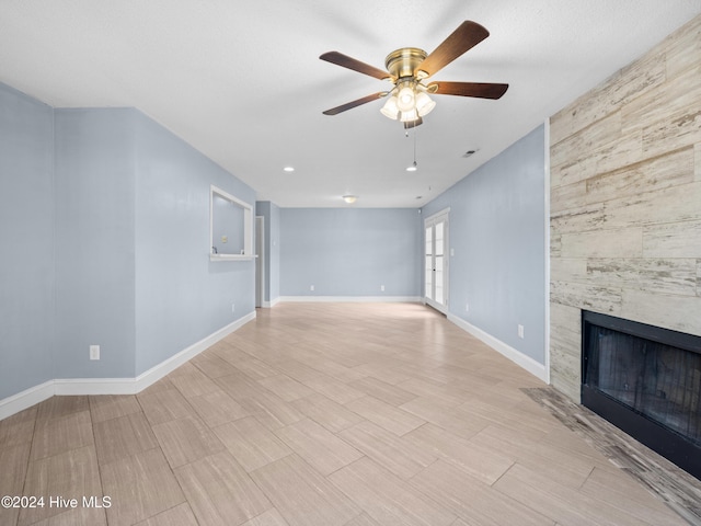 unfurnished living room featuring ceiling fan and a tile fireplace