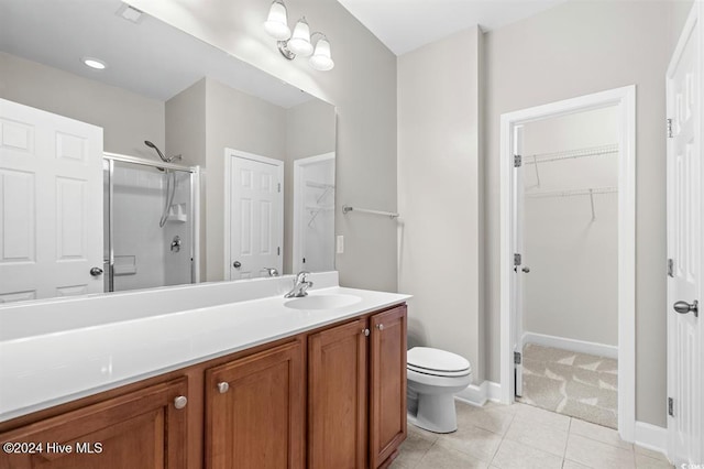 bathroom with tile patterned flooring, vanity, toilet, and walk in shower