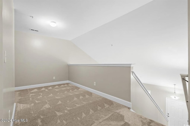 carpeted spare room featuring lofted ceiling