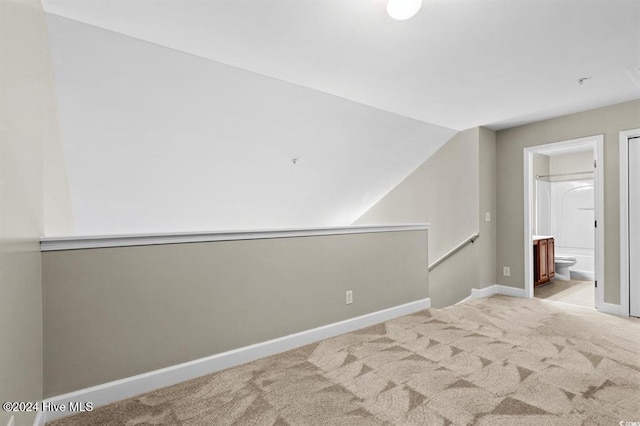 carpeted empty room featuring vaulted ceiling