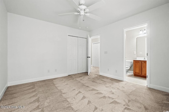 unfurnished bedroom featuring ensuite bath, ceiling fan, a closet, and light carpet