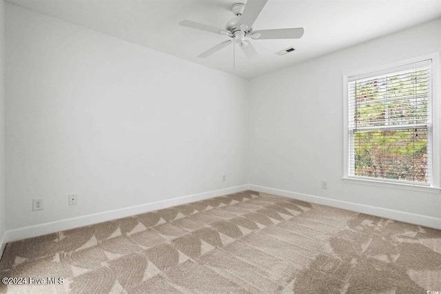 spare room with ceiling fan, light colored carpet, and a wealth of natural light