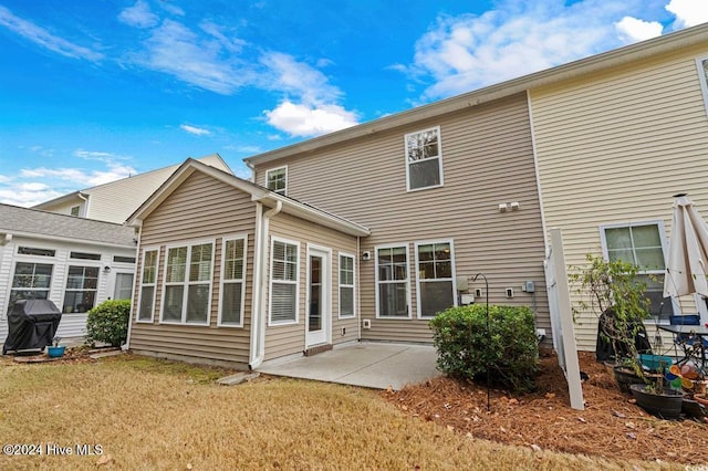 rear view of house featuring a yard and a patio