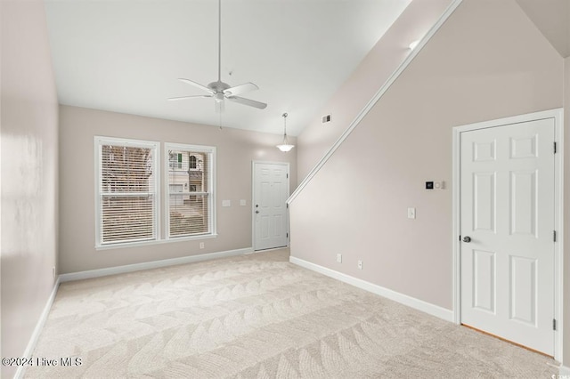 unfurnished room with ceiling fan, light colored carpet, and high vaulted ceiling