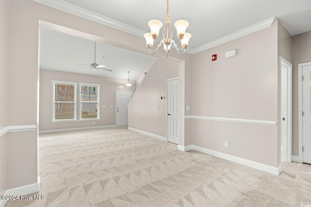 spare room featuring ceiling fan with notable chandelier, light colored carpet, and crown molding