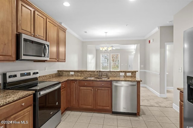 kitchen featuring kitchen peninsula, appliances with stainless steel finishes, dark stone counters, crown molding, and sink