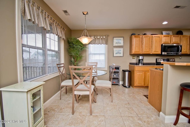 kitchen featuring light tile patterned floors, decorative light fixtures, and electric stove