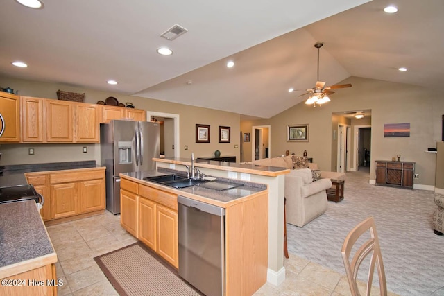 kitchen featuring appliances with stainless steel finishes, light brown cabinets, a center island with sink, and sink