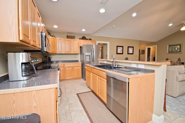 kitchen featuring light brown cabinets, sink, appliances with stainless steel finishes, and an island with sink