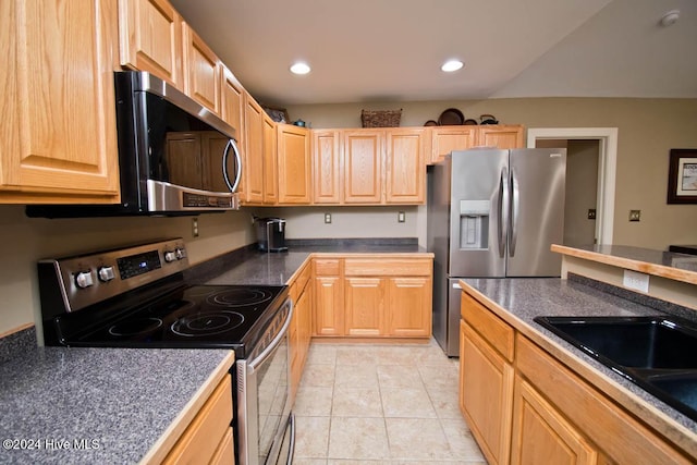 kitchen with sink, light brown cabinetry, light tile patterned flooring, and appliances with stainless steel finishes