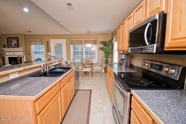 kitchen featuring stainless steel appliances, sink, light brown cabinets, pendant lighting, and light tile patterned flooring