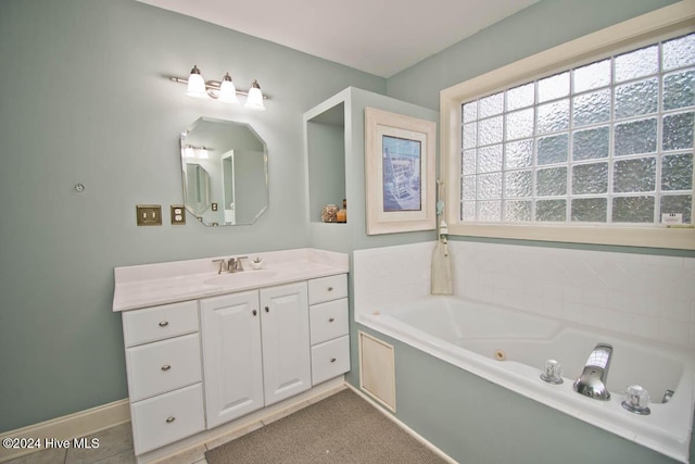 bathroom with tile patterned flooring, a bath, and vanity