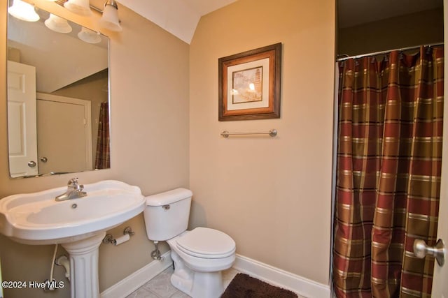 bathroom featuring toilet, tile patterned floors, and lofted ceiling